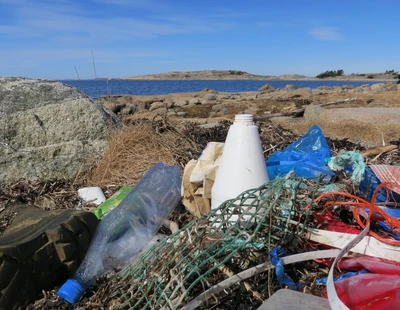 Plastflaskor och annat skräp på en strand på Bohuskusten