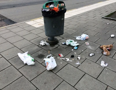 Överfull papperskorg i stadsmiljö