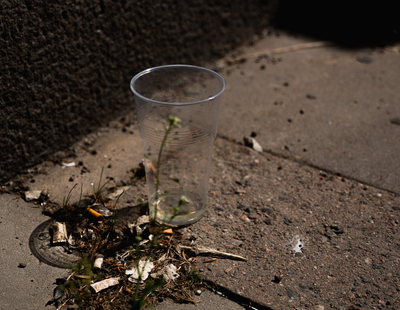 Några fimpar och en engångsmugg i plast ligger på marken