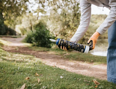 Kvinna plockar upp använd lustgastub i naturen