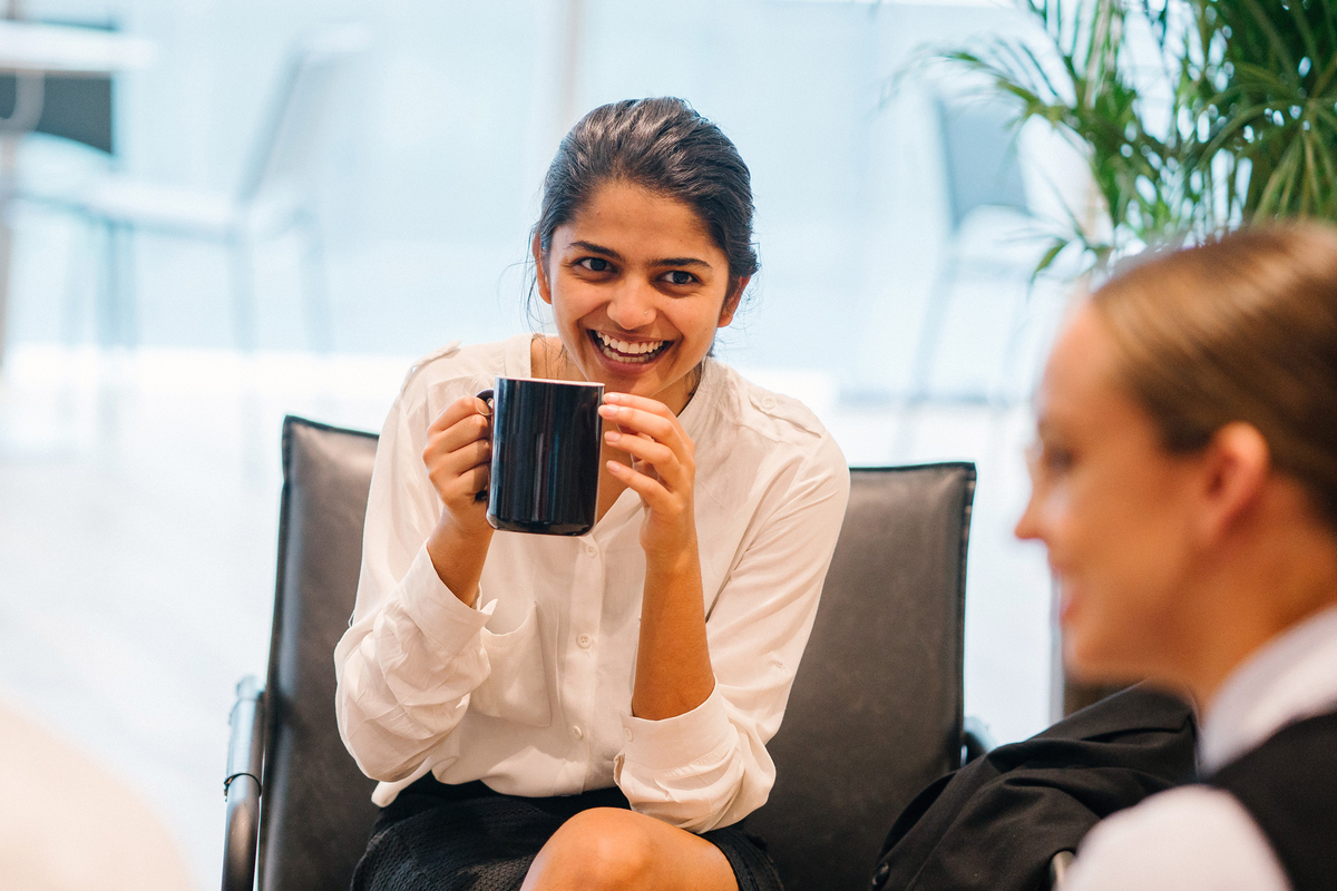 Kvinna dricker kaffe på kontoret