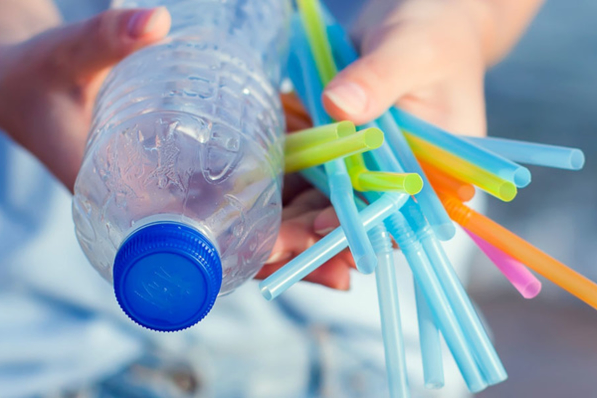 Person håller plastflaska och sugrör