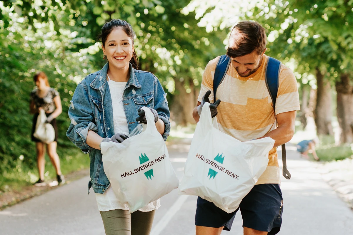 Två glada skräpplockare med varsin påse inför Håll Sverige Rent-dagen 2020.