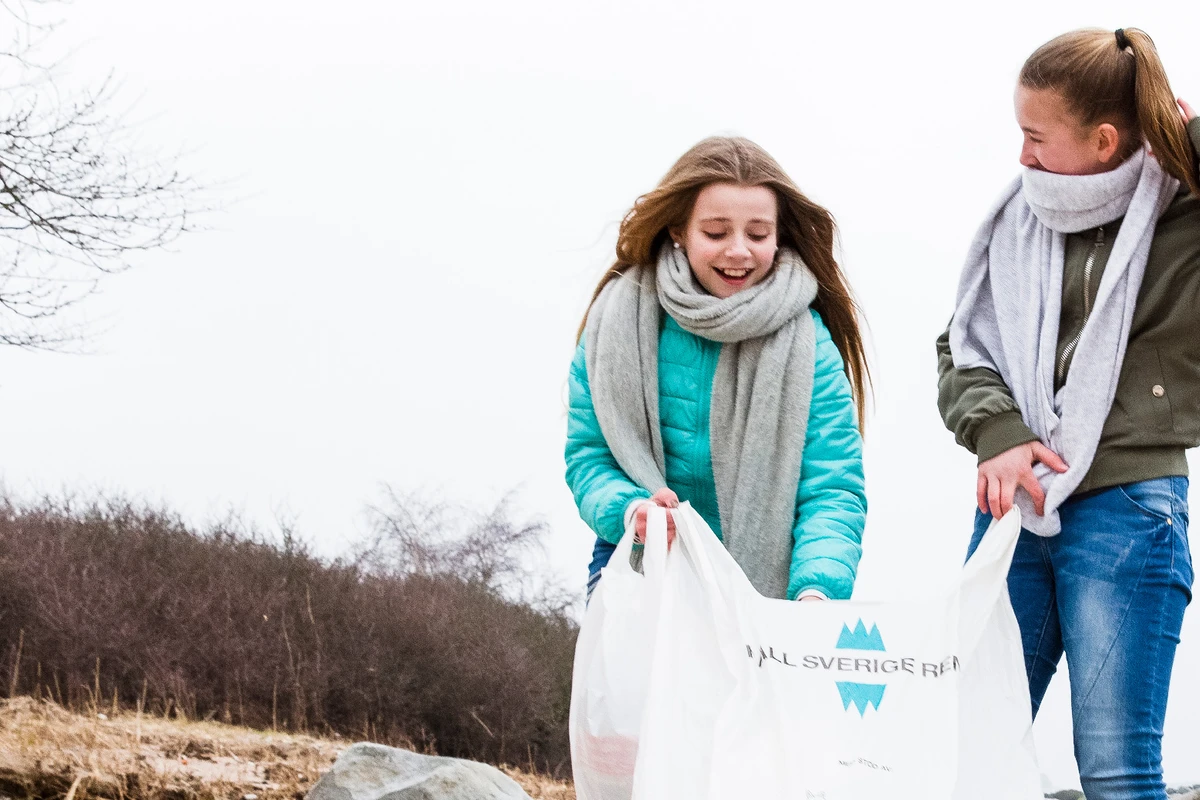 Två tjejer plockar skräp på strand. Foto: Jenny Brandt