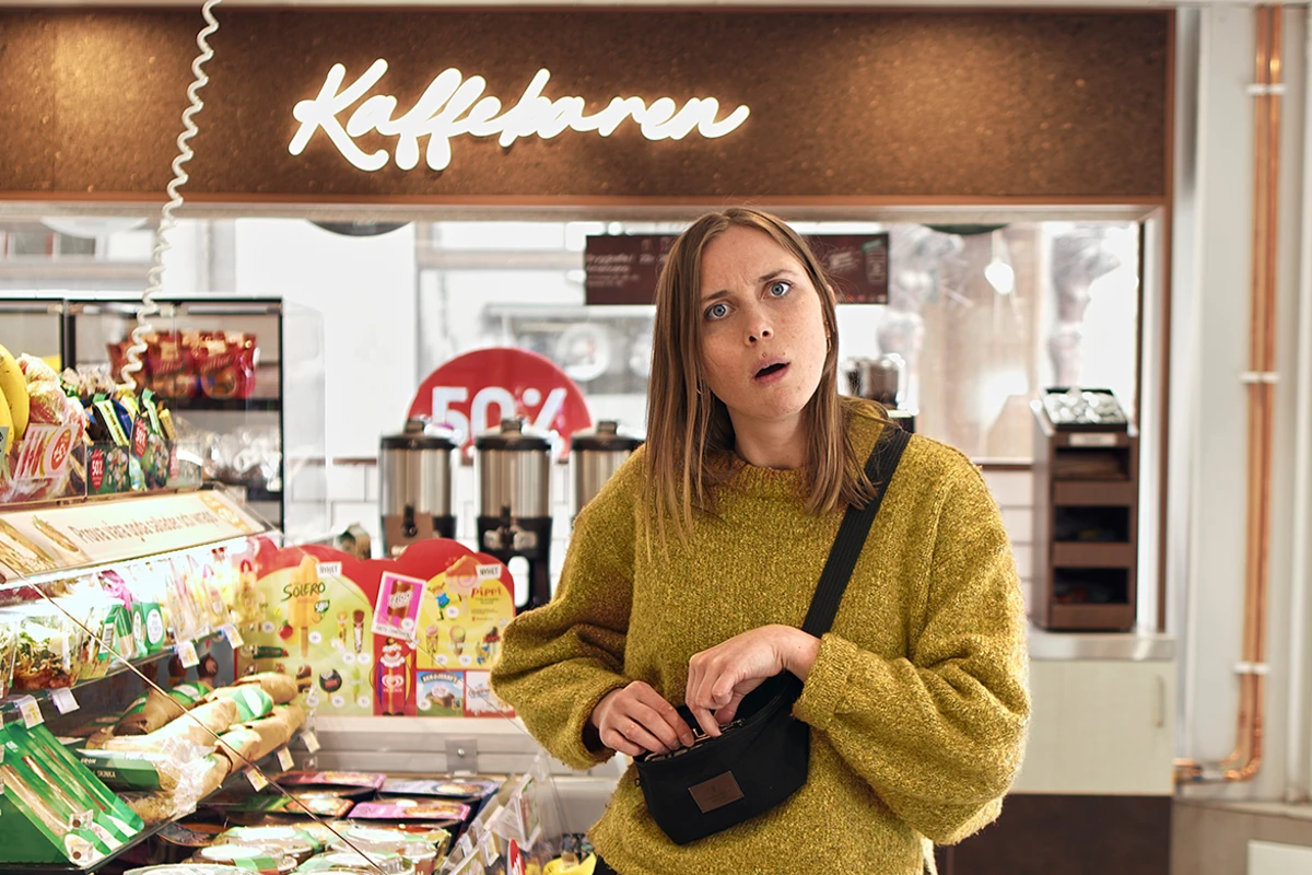 Tjej på café, ser förvånad ut.