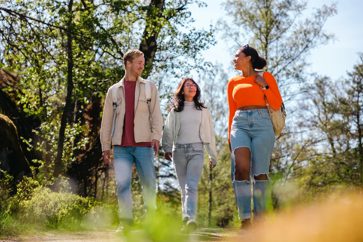 Tre kompisar på promenad i naturen