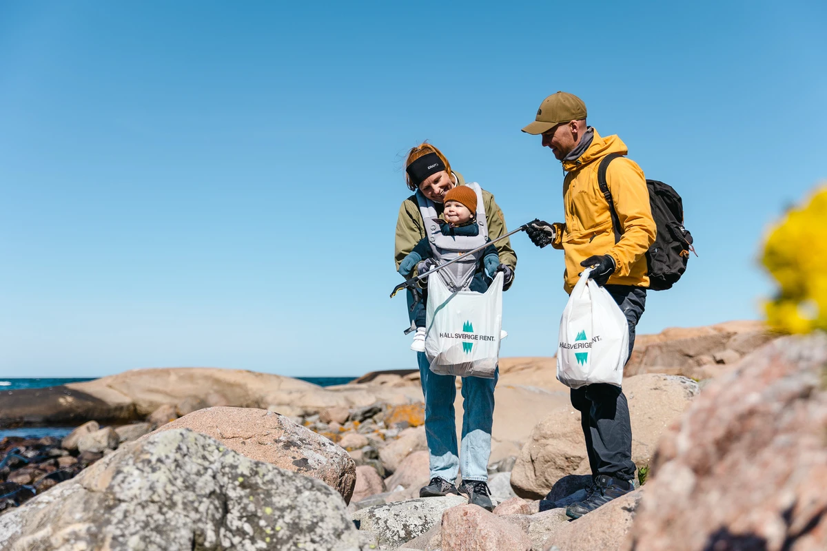 Familj plockar skräp vid klipporna
