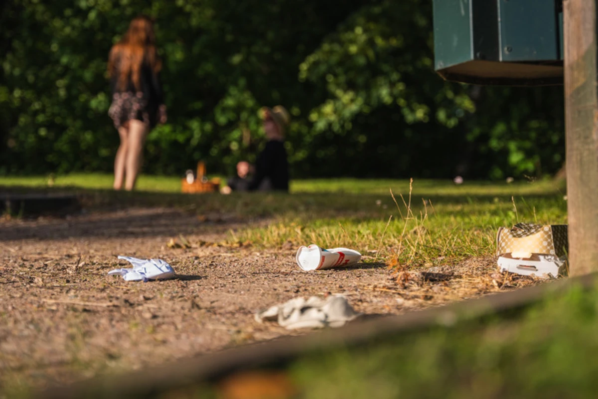 Engångsförpackningar ligger slängda på marken i en park
