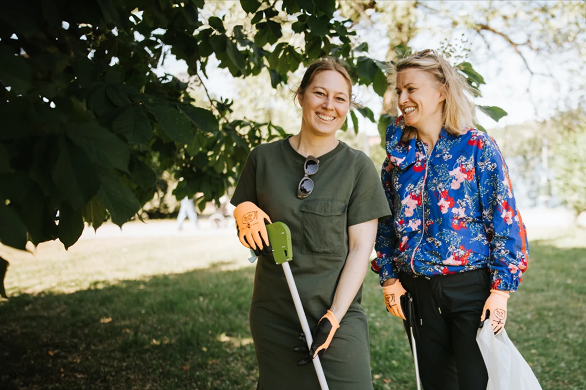 Två glada kvinnor under ett träd