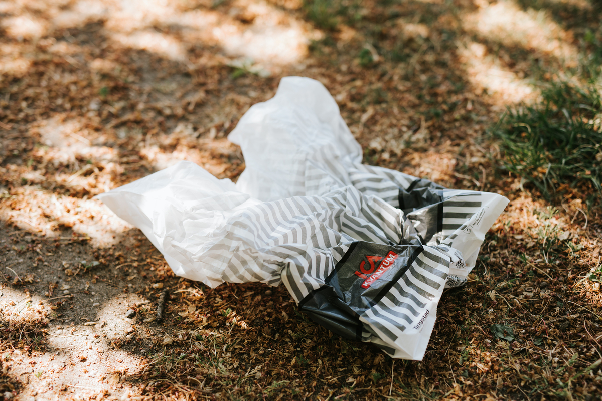 Skräpig plastpåse ligger på marken