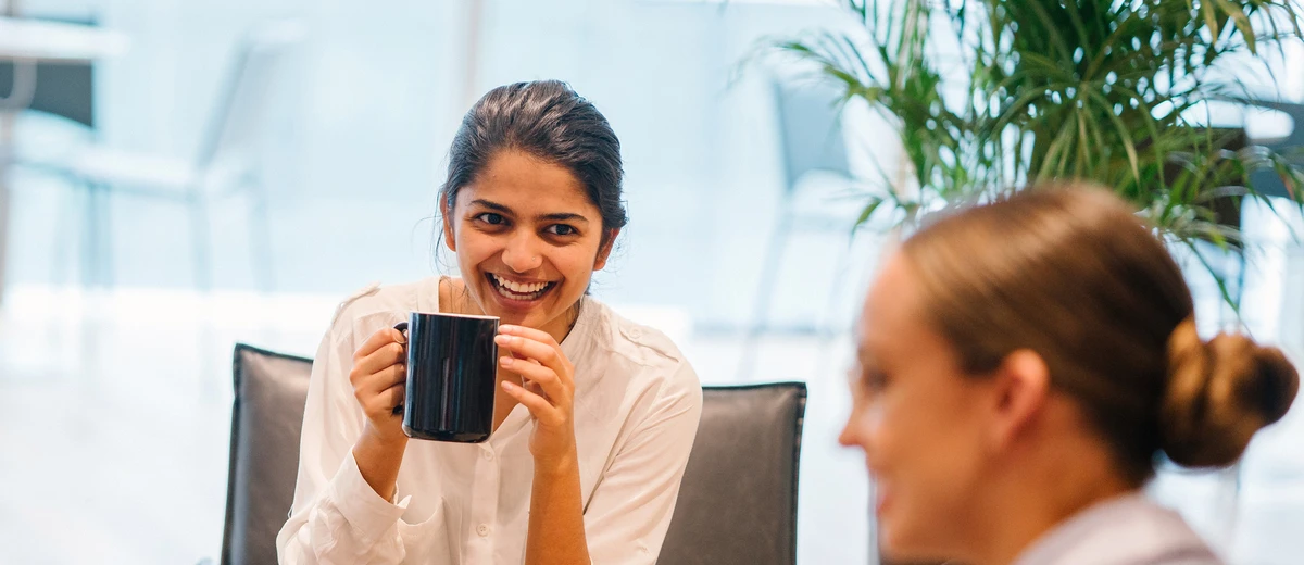 Kvinna dricker kaffe på kontoret