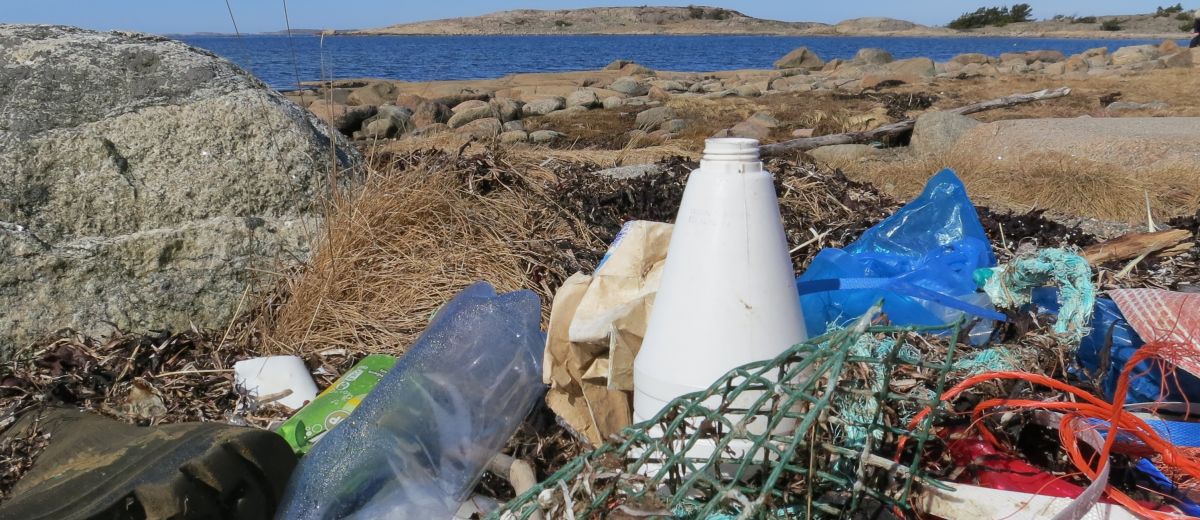 Plastflaskor och annat skräp på en strand på Bohuskusten