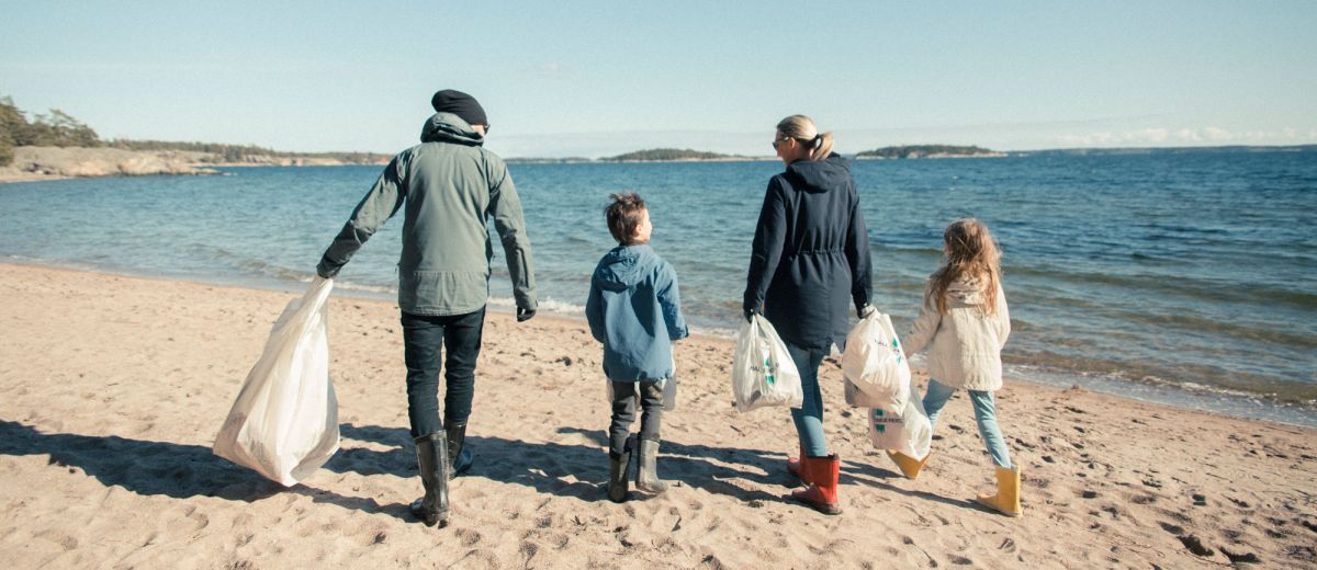 En familj plockar skräp på en strand. Foto: Sanna Holm