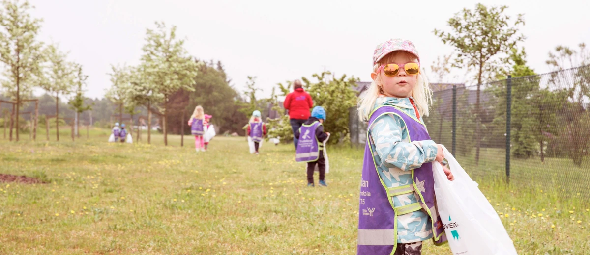 Tuff förskoletjej i solglasögon plockar skräp under Skräpplockardagarna. Foto: Jenny Brandt