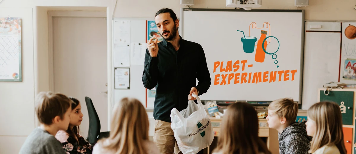 Lärare håller upp skräp med Plastexperimentets logga på whiteboard. Foto: Emma Grann