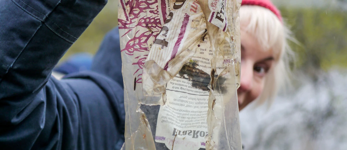 En person håller upp skräp framför ansiktet