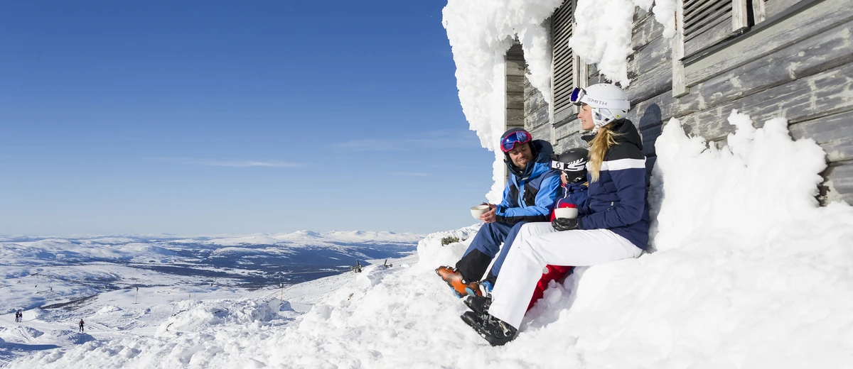 Två personer som fikar vid en skidbacke
