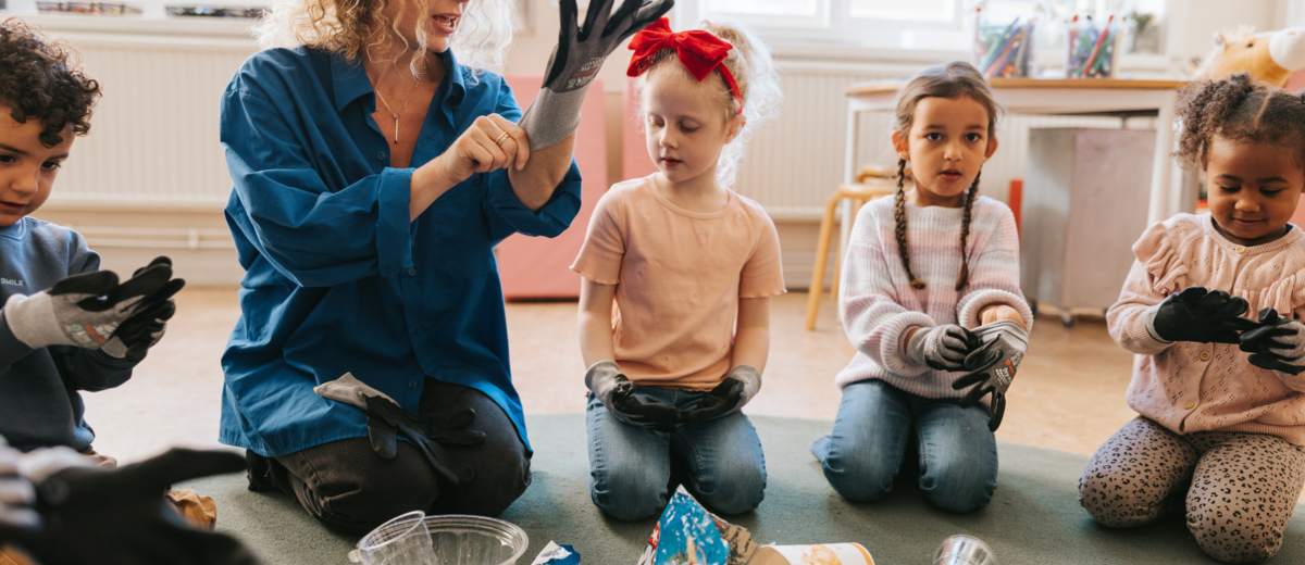 Lärare visar barn hur man tar på handskar