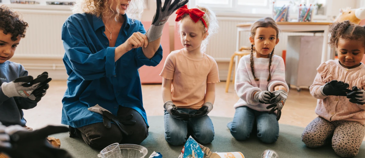 Lärare visar barn hur man tar på handskar