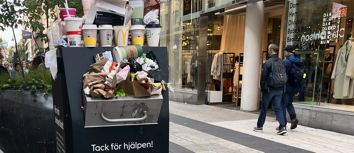 Engångsmuggar står på en papperskorg