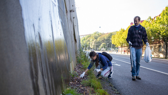 Två personer plockar skräp längs en gata i Göteborg