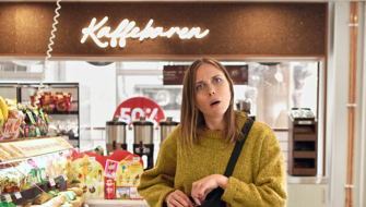 Tjej på café, ser förvånad ut.