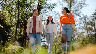 Tre kompisar på promenad i naturen