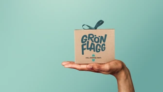 Hand håller i ett paket som det står Grön Flagg på