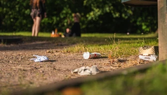 Engångsförpackningar ligger slängda på marken i en park