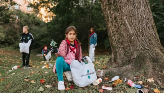 Flera barn plockar skräp i en park