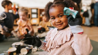 Flicka ler och håller fram skräp