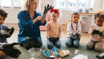 Lärare visar barn hur man tar på handskar