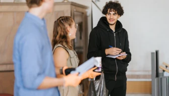 Tre elever pratar om skräp på en scen i aulan