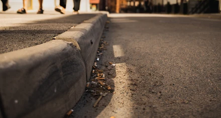 Fimpar ligger på marken intill en trottoar