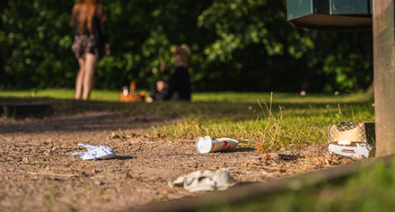 Engångsförpackningar ligger slängda på marken i en park