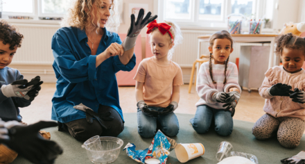 Lärare visar barn hur man tar på handskar
