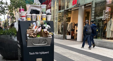 Engångsmuggar står på en papperskorg