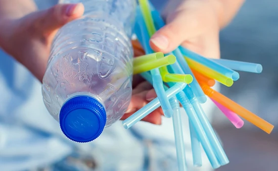 Person håller plastflaska och sugrör