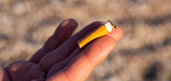 En hand håller upp en fimp