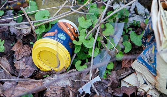 Take away-mugg ligger slängd i naturen