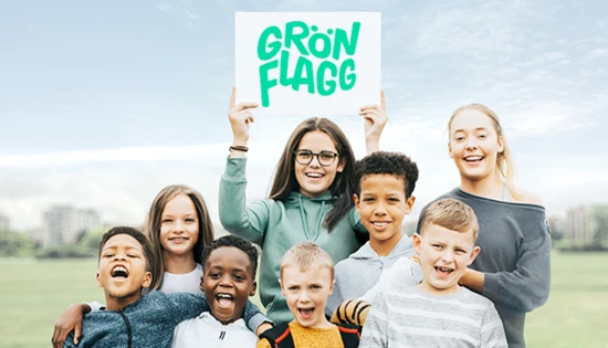 Barn håller upp en skylt med Grön Flagg