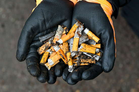 Händer håller fimpar och snus 
