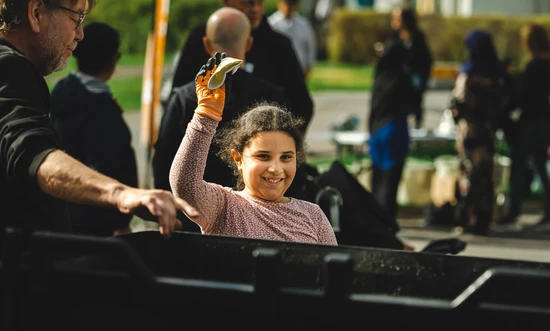 Flicka sorterar en pappersmugg på event i Navestad. Foto: Jonas Holmqvist