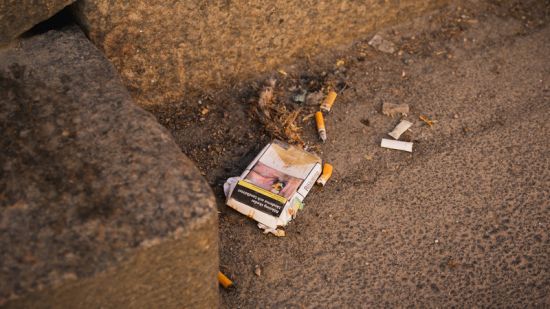Fimpar och cigarettpaket ligger på marken