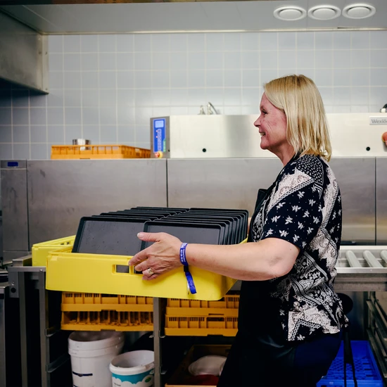 Kvinna bär flergångskärl mellan diskningsstationerna